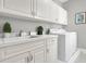 Laundry room with white cabinets, appliances, counter space and stainless steel sink at 45 Ocean Point Dr, Isle of Palms, SC 29451