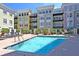 Community pool with lounge chairs, palm trees, and colorful condos surrounding the relaxation area at 498 Albemarle Rd # 306, Charleston, SC 29407