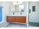Contemporary bathroom featuring dual sinks, wood cabinets, and a glass shower enclosure at 5541 Green Dolphin Way, Kiawah Island, SC 29455