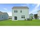 A lovely backyard with green lawn and a view of the home's light green exterior at 7014 Deanston Dr, Ravenel, SC 29470