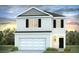Two-story home featuring neutral siding, a two-car garage, and a well-maintained lawn surrounded by trees at 7018 Deanston Dr, Ravenel, SC 29470