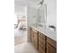 Bright bathroom featuring a double vanity with stone countertops, wood cabinets, and a glimpse into an adjacent bedroom at 711 Alma Square Dr, Moncks Corner, SC 29461