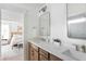 Bright bathroom featuring a double vanity with stone countertops, wood cabinets, and a glimpse into an adjacent bedroom at 711 Alma Square Dr, Moncks Corner, SC 29461