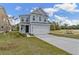 Charming two-story home with blue siding, a two-car garage, and a well-manicured front lawn at 711 Alma Square Dr, Moncks Corner, SC 29461