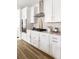 Modern white kitchen featuring sleek appliances, white subway tile backsplash, and hardwood floors at 711 Alma Square Dr, Moncks Corner, SC 29461