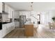 Bright kitchen featuring an island with stools, white cabinets, and stainless steel appliances at 711 Alma Square Dr, Moncks Corner, SC 29461