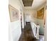 Hallway with hardwood floors leading to a bathroom and stairs at 715 Hampton St, Walterboro, SC 29488