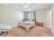Bedroom with neutral walls, ceiling fan, window, and closet; light brown carpeted flooring at 7791 Peppercorn Ln, North Charleston, SC 29420