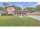 Charming brick home with an arched porch, benches, green lawn and a brick chimney at 7791 Peppercorn Ln, North Charleston, SC 29420