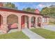 Inviting brick porch with arched entryways and cozy red benches at 7791 Peppercorn Ln, North Charleston, SC 29420