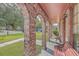 Covered porch with brick arches, red benches, and outdoor charm at 7791 Peppercorn Ln, North Charleston, SC 29420