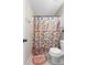 Bathroom with patterned shower curtain, toilet, and quirky 