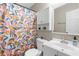Bright bathroom with colorful shower curtain, and storage above toilet at 7932 Riverbirch Ln, North Charleston, SC 29418