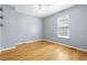 Well-lit bedroom with light blue walls, hardwood flooring, and a ceiling fan at 7932 Riverbirch Ln, North Charleston, SC 29418