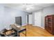 Another view of the bright office with hardwood floors, modern desk, and decorative cabinet at 7932 Riverbirch Ln, North Charleston, SC 29418