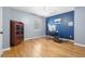 Office space featuring wood floors, navy blue accent wall, and built in shelving unit at 7932 Riverbirch Ln, North Charleston, SC 29418