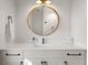 Bright bathroom boasts a white vanity with dark hardware and a round mirror with a wood trim at 8067 Jack Island Dr, Johns Island, SC 29455