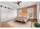 Modern bedroom with wood accent wall, barn door, and stylish furnishings, creating a cozy retreat at 8067 Jack Island Dr, Johns Island, SC 29455