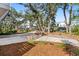 A long concrete driveway leads to homes surrounded by mature trees and landscaping at 8067 Jack Island Dr, Johns Island, SC 29455