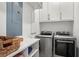Functional laundry room featuring modern washer and dryer, storage cabinets and folding counter at 8067 Jack Island Dr, Johns Island, SC 29455