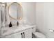 Elegant powder room features marble countertop, brass fixtures, and a wood framed mirror at 8067 Jack Island Dr, Johns Island, SC 29455