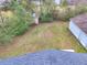 Backyard view shows a large lot, bordered by lush bushes and trees, and includes a storage shed at 847 Quail Dr, Charleston, SC 29412