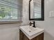 Modern bathroom vanity with a sleek sink, stylish faucet, and a large mirror reflecting natural light from the window at 847 Quail Dr, Charleston, SC 29412