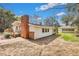 View of the home's side exterior with brick chimney, a wooden deck, and a detached garage at 847 Quail Dr, Charleston, SC 29412