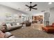 Open concept living room flowing into kitchen area with a ceiling fan and a cozy seating arrangement at 9000 Hema Ln, Summerville, SC 29483