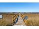 Scenic wooden pier extending over tranquil waters, offering a serene retreat with views of the distant cityscape at 939 White Point Blvd, Charleston, SC 29412