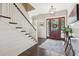 Inviting foyer with wainscoting, dark wood floors, stylish light fixture, and a glimpse of the outdoors at 939 White Point Blvd, Charleston, SC 29412