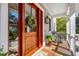 Charming front porch with a stained wood door, decorative wreath, and stylish rocking chair for relaxing at 939 White Point Blvd, Charleston, SC 29412