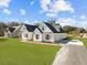 New home exterior features white siding, black roof, and lush green lawn with long driveway at 00 N Highway 17, McClellanville, SC 29458