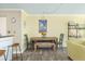 Cozy dining area with charming furnishings, a wood table with an artistic painting, and a view of the living space at 102 Mariners Cay Dr, Folly Beach, SC 29439