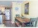 Comfortable dining area with wooden table, colorful bench, and stainless steel refrigerator in a cozy setting at 102 Mariners Cay Dr, Folly Beach, SC 29439