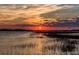 Stunning sunset over the water, reflecting on the calm surface, in this waterfront community at 102 Mariners Cay Dr, Folly Beach, SC 29439