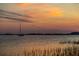 Peaceful waterfront view with a boat at sunset, offering a serene and beautiful setting for residents at 102 Mariners Cay Dr, Folly Beach, SC 29439