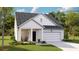 Charming single-Gathering home featuring a covered porch, well-maintained lawn, and an attached garage at 1033 Swamp Rose Run, Summerville, SC 29485