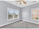 Bedroom featuring neutral carpet and trim, two windows, and light grey walls at 1070 Moss Grove Dr, Moncks Corner, SC 29461