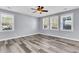 Serene bedroom with hardwood floors, ceiling fan, and abundant natural light from large windows at 1070 Moss Grove Dr, Moncks Corner, SC 29461