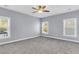 Bright bedroom with carpet, neutral walls, ceiling fan, and lots of natural light from the windows at 1070 Moss Grove Dr, Moncks Corner, SC 29461