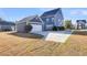 Exterior view of a blue two-story home with a detached garage and concrete driveway at 1070 Moss Grove Dr, Moncks Corner, SC 29461
