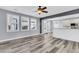 Open-concept living room with modern flooring, ceiling fan, and seamless flow to kitchen and outdoor space at 1070 Moss Grove Dr, Moncks Corner, SC 29461