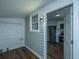 A doorway opens to reveal a kitchen with white cabinets and stainless steel appliances, connecting indoor spaces at 111 Carver St, Walterboro, SC 29488