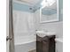 This bathroom features white wainscoting, light-blue walls, a tub, shower, and vanity at 1117 Oceanview Rd, Charleston, SC 29412