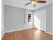 This bedroom features gray walls, wood floors, a window, ceiling fan, and white bi-fold doors at 1117 Oceanview Rd, Charleston, SC 29412