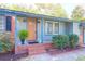 Cozy covered front porch with brick steps and a vibrant green fern, inviting curb appeal at 1117 Oceanview Rd, Charleston, SC 29412