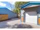 Exterior shot of a blue garage with a white garage door and a gravel driveway at 1117 Oceanview Rd, Charleston, SC 29412