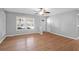 Sun-filled living room featuring gleaming hardwood floors, a ceiling fan, and a white accent wall at 1117 Oceanview Rd, Charleston, SC 29412