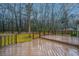 Large, wet wooden deck with railings overlooks a wooded backyard, ideal for outdoor entertaining at 112 Ravenswood Ct, Summerville, SC 29485